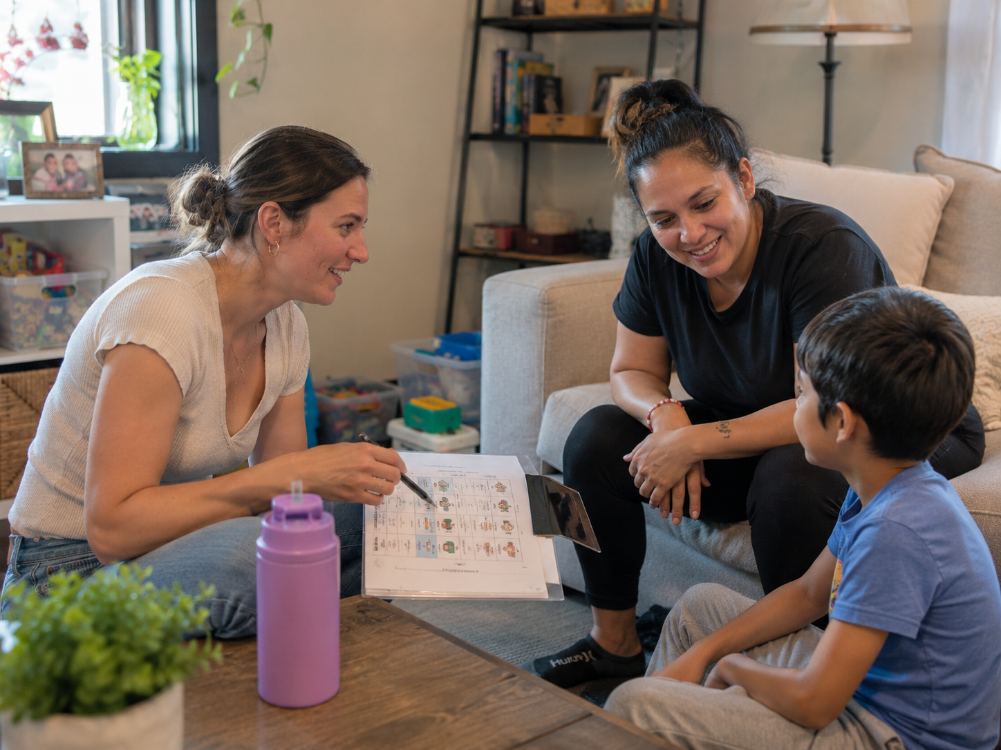 A BCBA coaching a parent and child at home using a visual schedule
